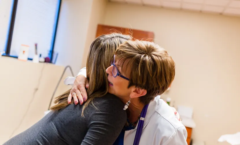 Midwife and mother hugging