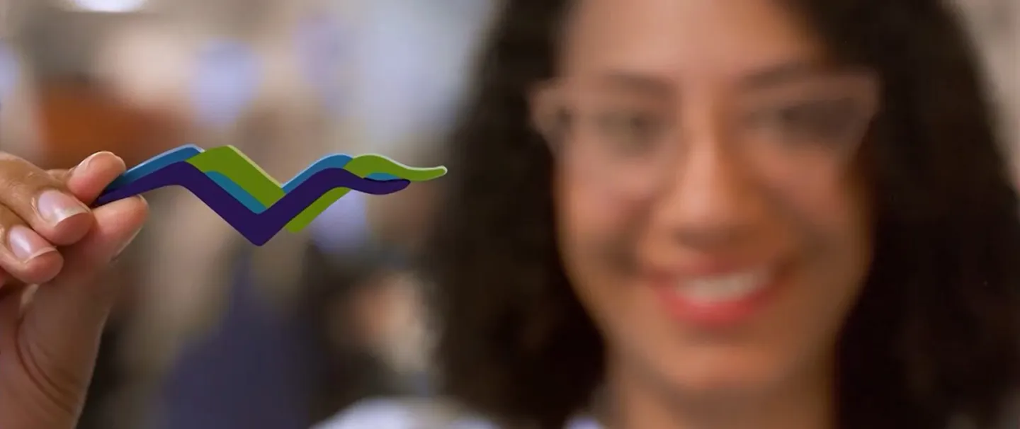 Monique Nugent, MD of South Shore Health holds up a small wooden version of the South Shore Health gulls logo