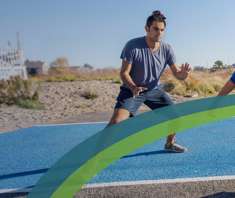 A man and child play basketball near the beach