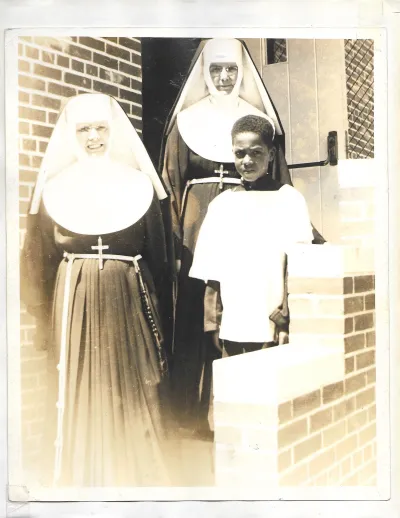 Two nuns with a Black altar boy