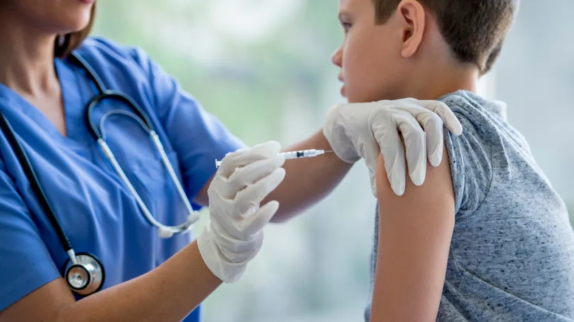 Child being given a flu shot by a nurse