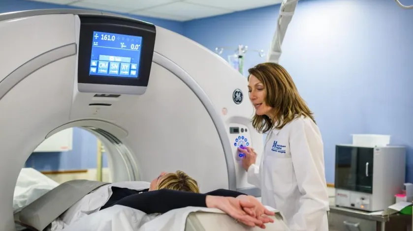 Woman in machine for diagnostic imaging