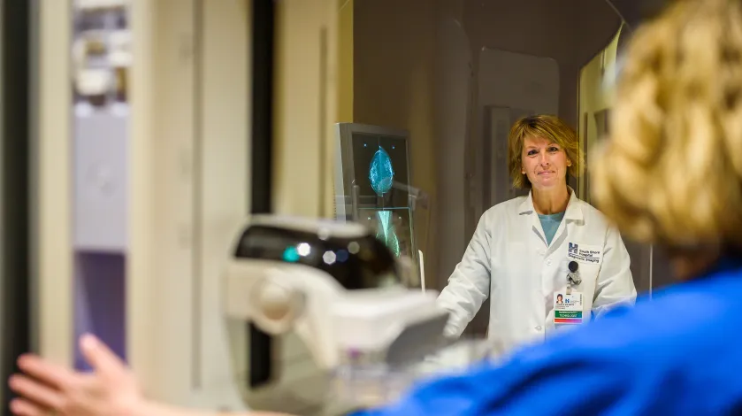 Technologist preparing woman for mammogram