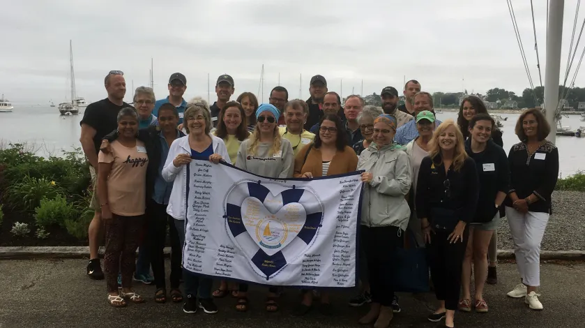 Patients and boat captains pose for a photo as part of Sailing Heals