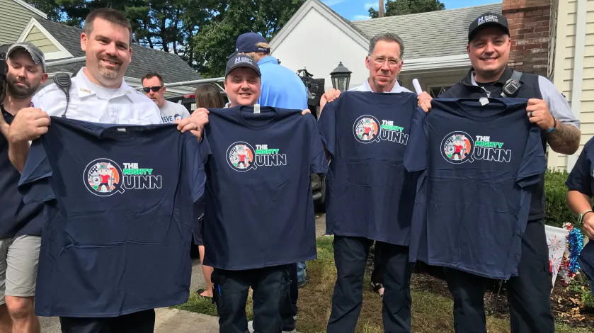 South Shore EMS hold up their Mighty Quinn t-shirts at Quinn Waters' house