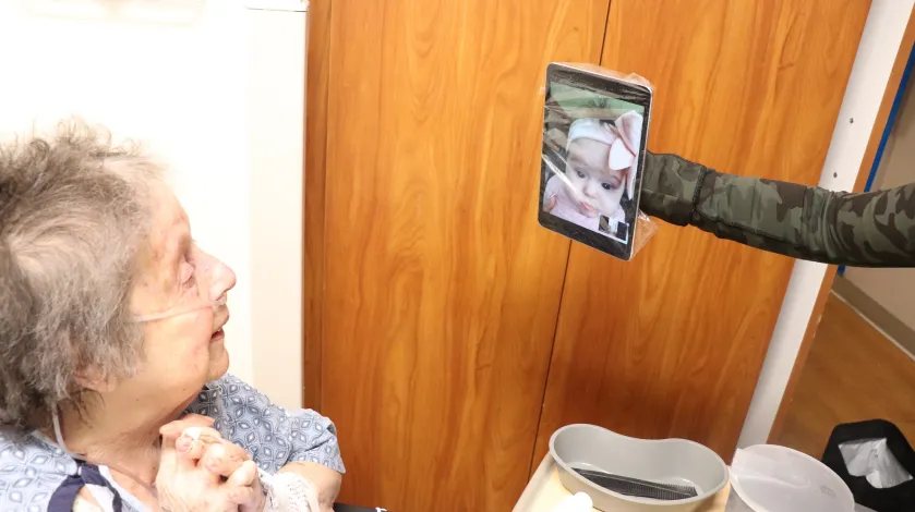 A hospital patient video chats with her great granddaughter during the COVID-19 pandemic.