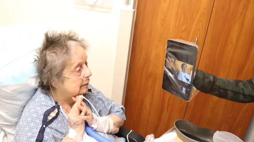 A hospital patient video chats with her family during the COVID-19 pandemic.