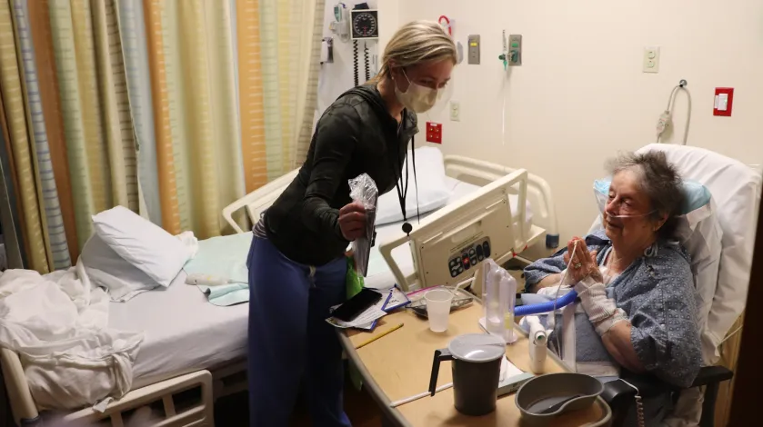 A hospital patient video chats with family members during the COVID-19 pandemic.