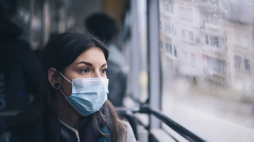woman riding transportation while wearing a face mask