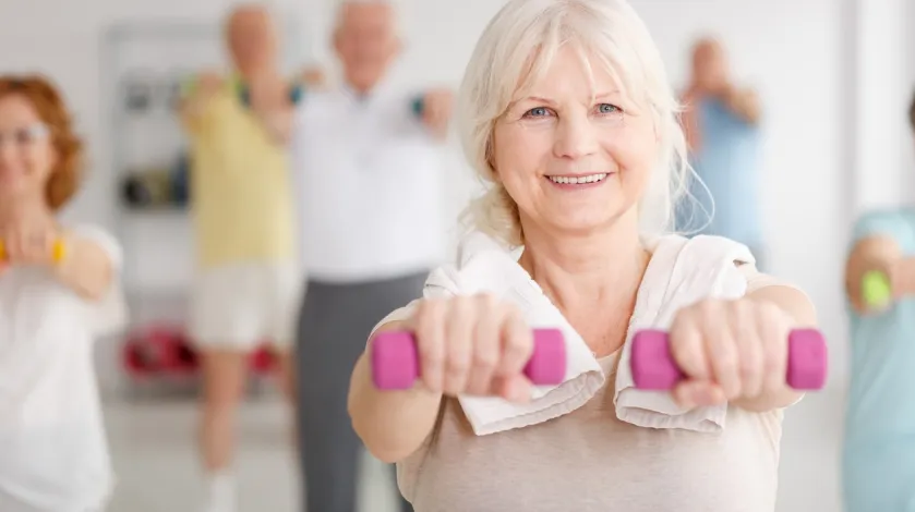 Older woman working out with hand weights at a community exercise class