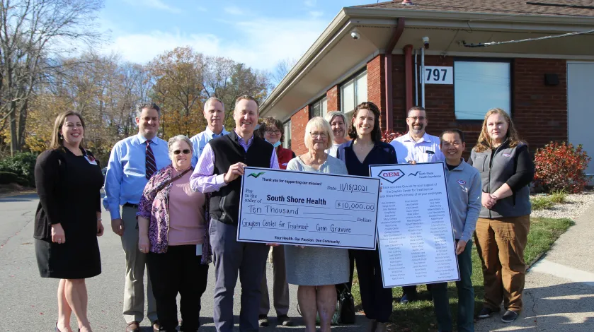 Employees from Gem Gravure of Hanover pose for a photo outside of 797 Main Street in Weymouth after making a $10,000 donation to South Shore Health.