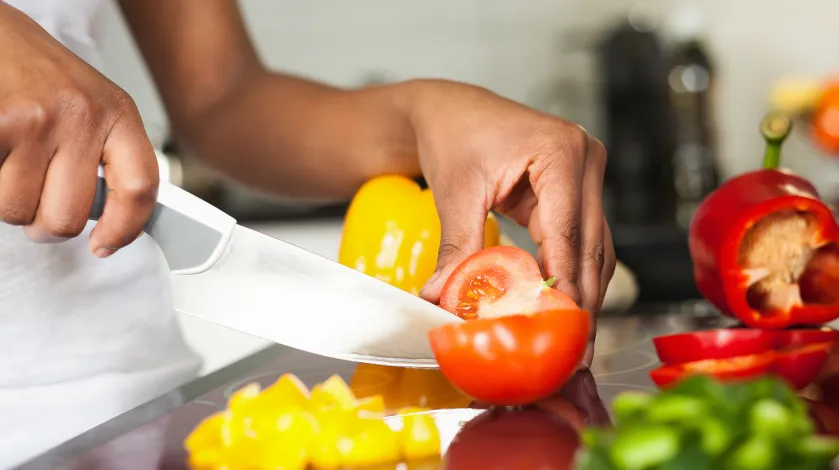 Woman chopping tomatoes and peppers