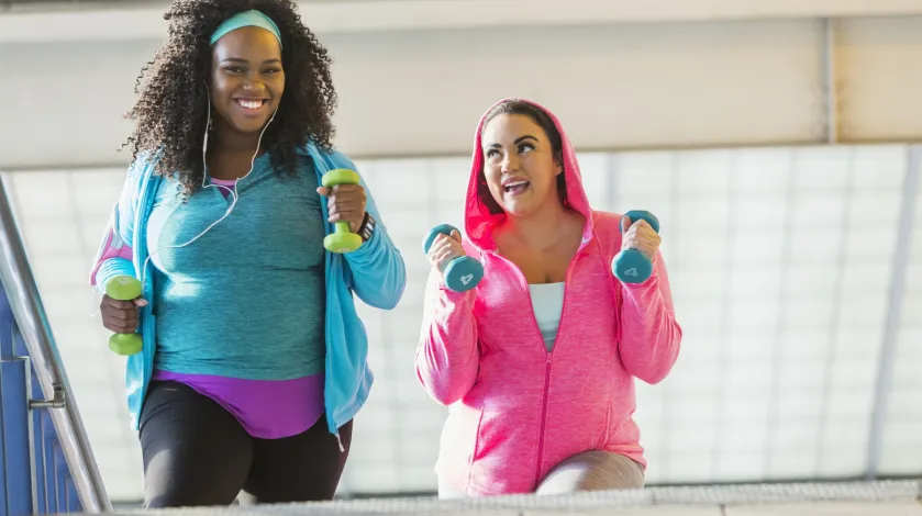 Two women exercising with free weights