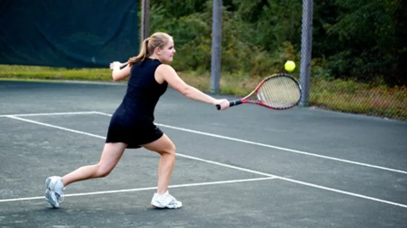 Caroline McCarthy prepares to hit a tennis shot with her backhand.