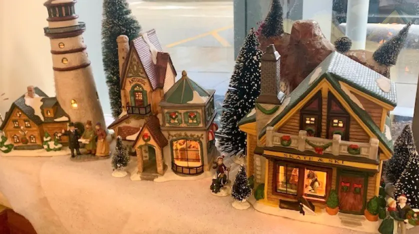 A lighthouse and buildings in a winter village display