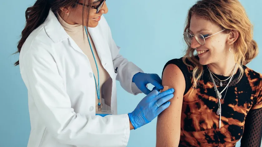 Female doctor gives teen girl a vaccine