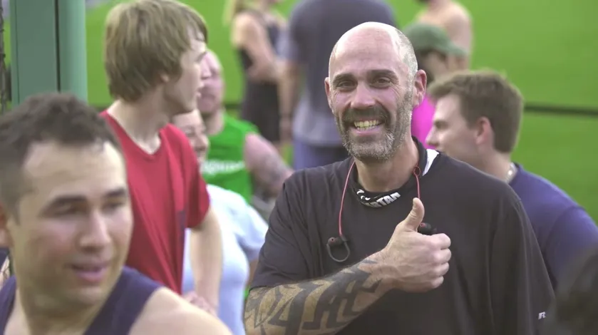 Mark P. smiles and gives a thumbs up to the camera after competing at a recent Spartan race