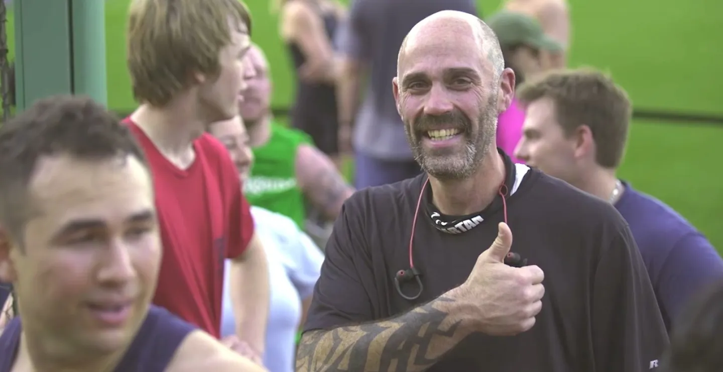 Mark P. smiles and gives a thumbs up to the camera after competing at a recent Spartan race
