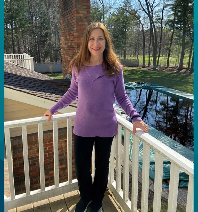Patient Jo-Ann stands on her deck for a photo. Jo-Ann shared her story of her same-day joint replacement procedure at South Shore Health.