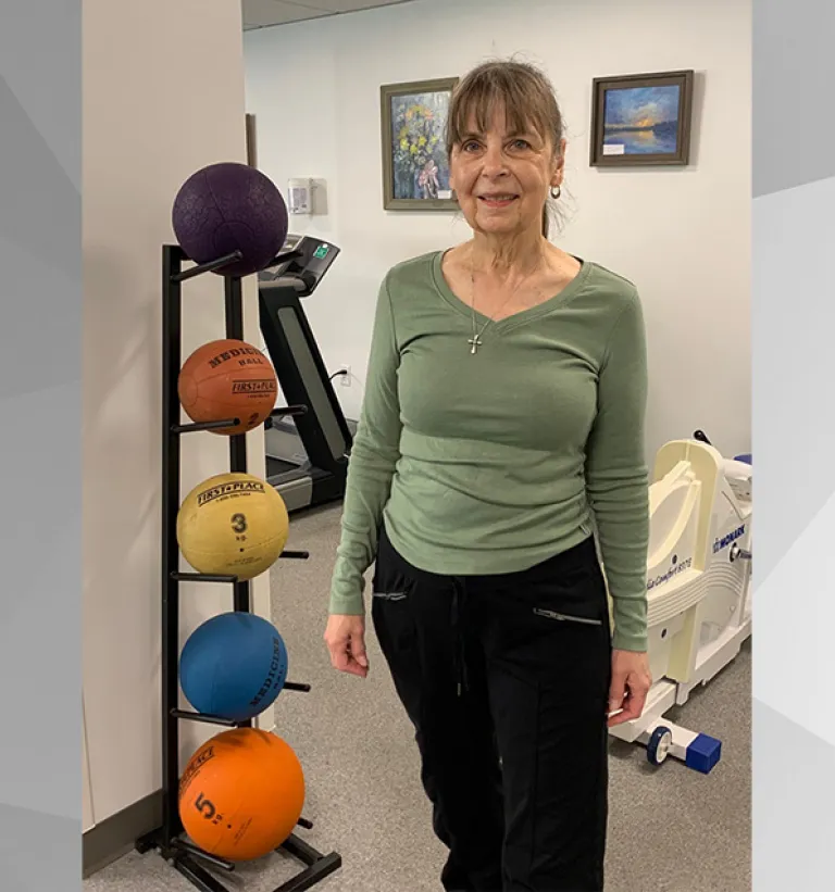 Ruth of Weymouth poses in front of medicine balls and a spinning back prior to her community exercise class at South Shore Health