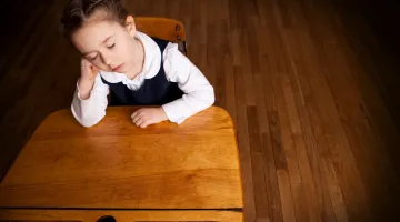 Child sleeping at school desk