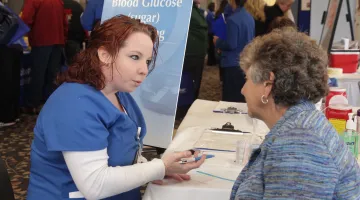 Nurse speaking with older woman at a blood drive