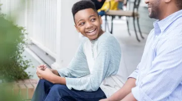 Boy talking to dad about staying home alone