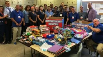 Team of volunteers surrounding table with donations