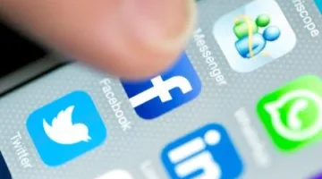 Finger hitting Facebook app on a smart phone