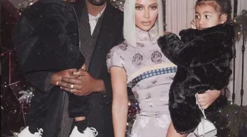Kim Kardashian and Kanye West holding thier two children