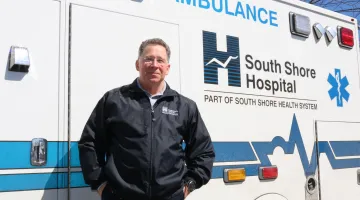 Paul Hughes, EMS Coordinator for South Shore EMS, in front of ambulance