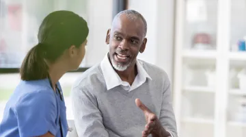 A man talks to his healthcare provider in an office