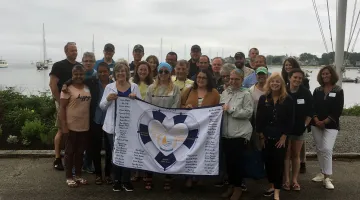 Patients and boat captains pose for a photo as part of Sailing Heals