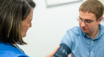 A provider puts a blood pressure band on a patient's arm