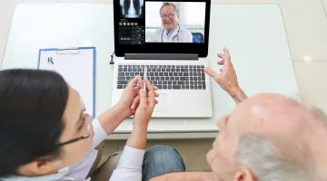 A patient and a caregiver speak to a doctor on the phone