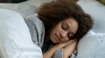 A young woman sleeps peacefully in bed