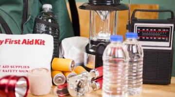 An emergency preparedness kit, featuring a radio, bottled water, a lantern, and other supplies.