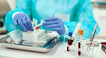 Close-up view of a laboratory worker working with vials of blood doing general lab work