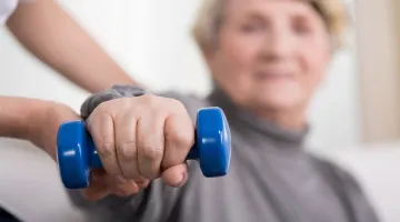 Woman using a weight for hand therapy