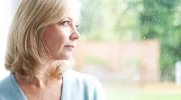Sad looking woman gazing out of window