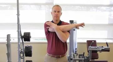 Rob Shirley, PT, DPT of South Shore Health demonstrates a shoulder stretch at the rehabilitation gym