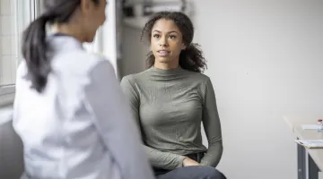 A female doctor speaks to a young woman