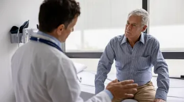 A doctor consults with a older male patient