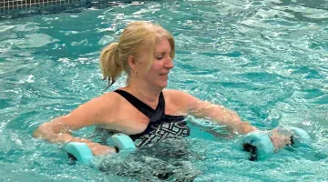 Woman works out with weights in a pool class