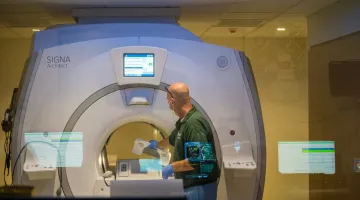 A technician prepares an MRI machine at South Shore Hospital for use by a patient.